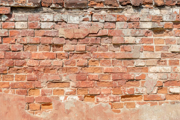 abstract background of an old brick wall with peeling plaster close up