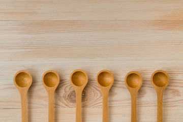 Set of wooden spoons on wooden background, copy space
