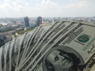 Stack of american dollars on urban background. A lot of American dollars on the background of urban...