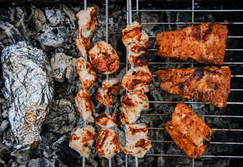 Juicy Pork steak, ribs and chicken meat on bbq grill, homemade barbecue, closeup.