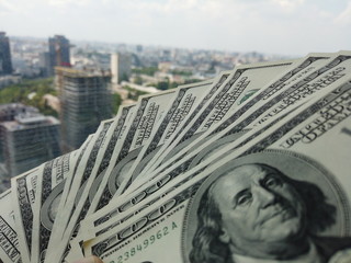 Stack of american dollars on urban background. A lot of American dollars on the background of urban...
