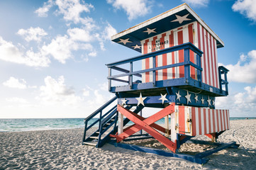 Classic red, white, and blue American flag themed lifeguard tower, now retired, on the sand in South Beach, Miami, Florida, USA