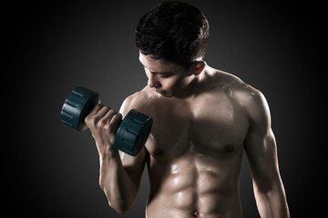 Fototapeta na wymiar Shirtless young man exercising his muscular biceps