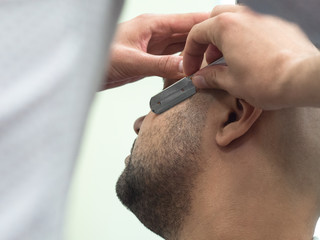 Shaving the beard in the Barber shop. Close up