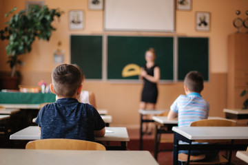 Back view of children sitting in the class room and study. Elementary school