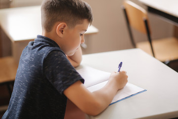 Fototapeta premium Boy and girl sitting at desk and writing a text