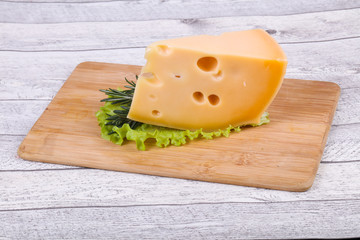 Maasdam cheese  in the board served salad leaves