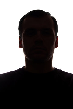 Portrait of a young man, front view - dark isolated silhouette