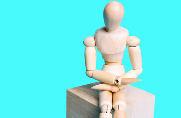 Wooden human figure on a blue background. Concept of abdominal pain,  artificial intelligence.