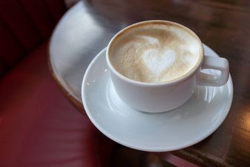 Cup coffee hot Cappuchino on red table with sunlight and shadow