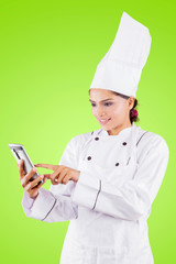 Young female chef using a phone on studio