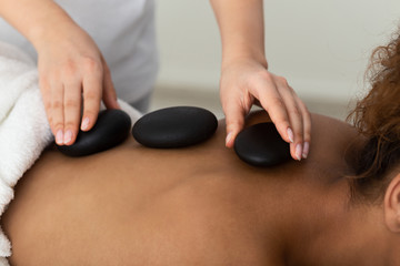 Stone Massage. Woman Receiving Hot Back Massage