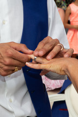 Groom gently wears wedding ring in marriage day in bride hand