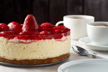 Cheesecake with strawberries and two cups of tea