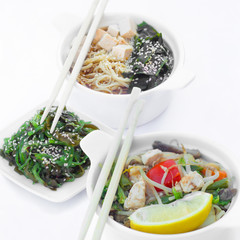 Isolated chinese food on a white background. Food is placed in the pot. Nearby lie chopsticks.