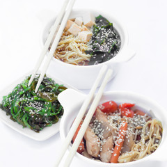 Isolated chinese food on a white background. Food is placed in the pot. Nearby lie chopsticks.