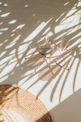 Fashion composition with women's accessories on white background. Sunglasses, straw hat on white background. Flat lay, top view trendy french style lifestyle blog concept.