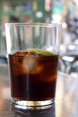 Glass of cola with ice at an outdoor restaurant and bar