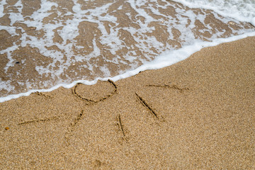 Sun drawn on the beach, ocean.