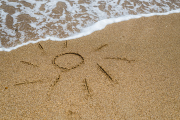Sun drawn on the beach, ocean.