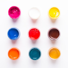 Multicolored gouache on a white background Isolated Paints in containers Top view