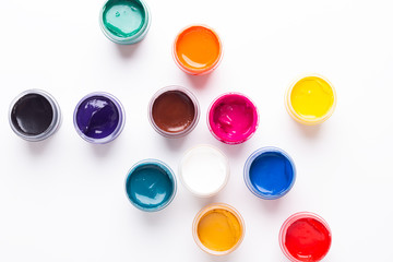 Multicolored gouache on a white background Isolated Paints in containers Top view