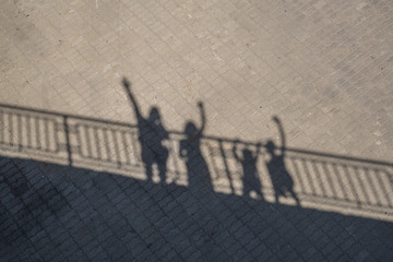 The shadow of people waving from the bridge.