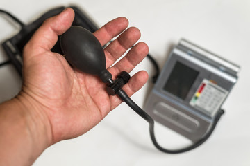 Male hand is holding a device for measuring blood pressure.