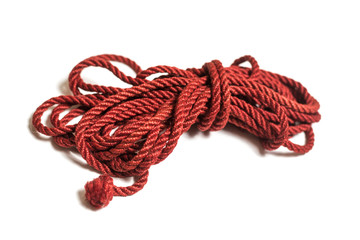Red jute rope for shibari isolated on white background.