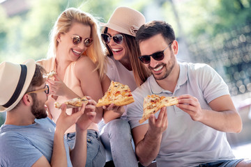 Cheerful friends eat pizza together