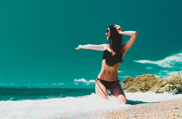 beautiful young woman sitting on the wonderful sand beach in greece