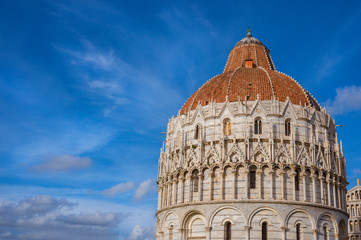 Pisa Baptistry gothic medieval dome among clouds just before sunset