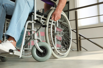 Senior man sitting in wheelchair indoors, closeup