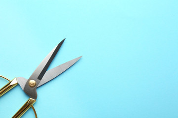 Pair of sharp scissors on color background, top view. Space for text