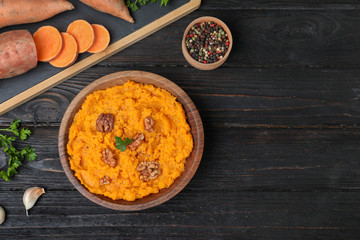 Flat lay composition with mashed sweet potatoes on wooden background, space for text