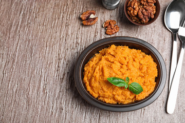 Flat lay composition with mashed sweet potatoes on brown background, space for text