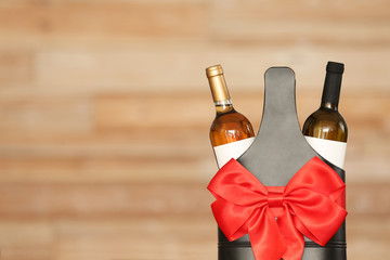 Festive package with bottles of wine against blurred background. Space for text