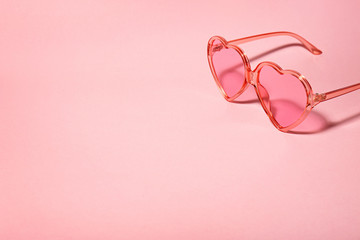 Stylish heart shaped glasses on color background. Space for text