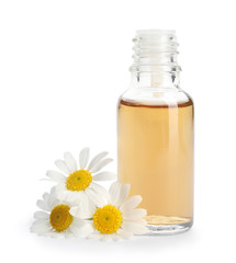 Chamomile flowers and cosmetic bottle of essential oil on white background