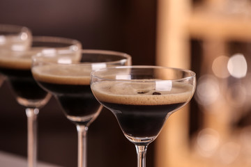 Glasses of delicious Espresso Martini on blurred background. Alcohol cocktail