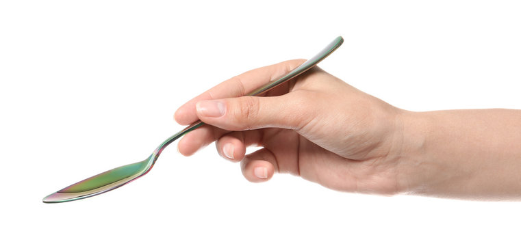 Woman holding clean tablespoon on white background, closeup