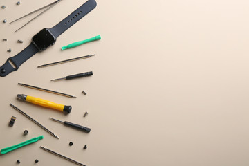 Flat lay composition of broken smart watch and tools on color background, space for text. Repair service