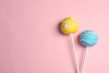 Bright delicious cake pops on color background, flat lay. Space for text