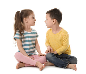 Cute little boy and girl sitting on white background