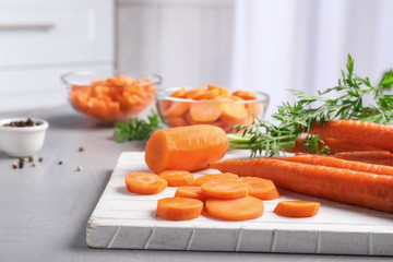 Board with slices of carrot on table