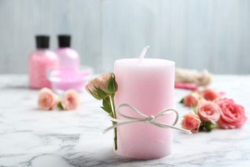 Scented candle with roses on marble table