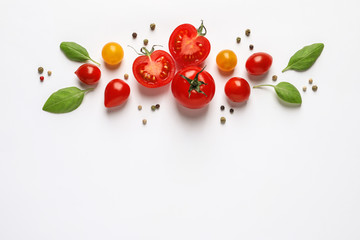 Composition with ripe cherry tomatoes and basil leaves on white background, top view