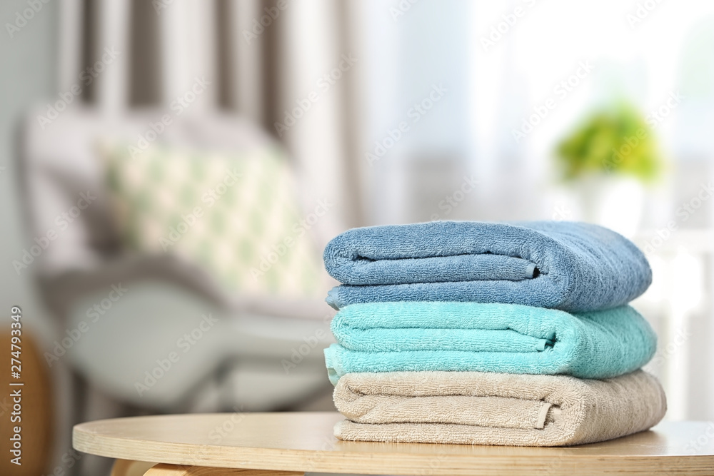 Poster Stack of folded clean soft towels on table indoors. Space for text