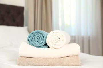 Fototapeta na wymiar Soft clean terry towels on bed in room
