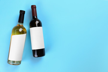 Bottles of wine on colorful background, flat lay. Space for text